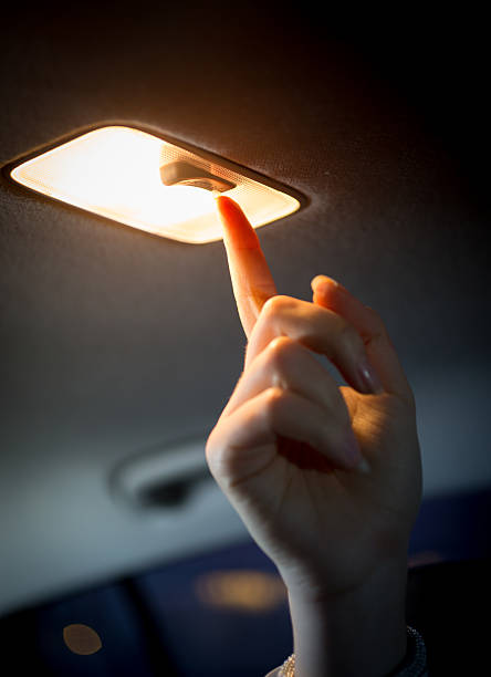 frau drehen licht in auto-salon - car indoors inside of vehicle interior stock-fotos und bilder