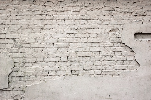 Old Broken Damaged Weathered Plastered Painted White Brick Wall  With Chuckhole Abstract Isolated Background Texture