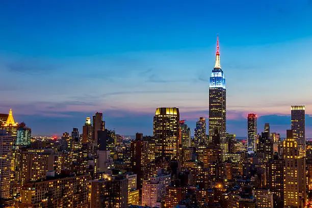 Photo of New York City skyline with urban skyscrapers at sunset.