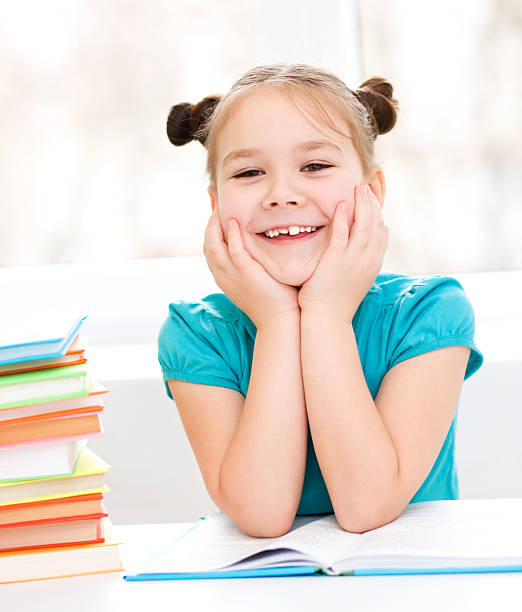 istock Little girl is reading a book 480220489