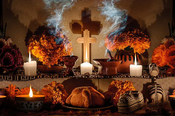 Traditional mexican Day of the dead altar with pan de muerto and candles
