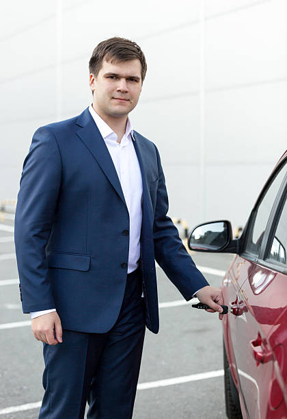 istock handsome young businessman opening car door 480224694