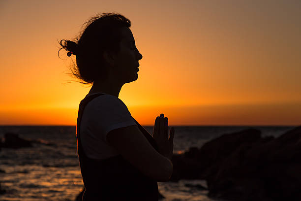 istock Silhouette young woman practicing yoga on the beach at sunset. 480224800