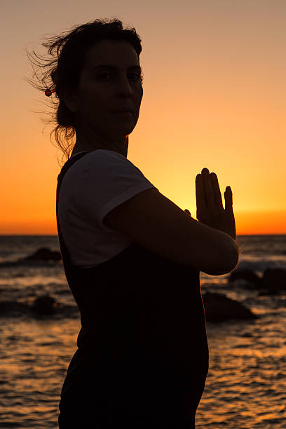 istock Silhouette young woman practicing yoga on the beach at sunset. 480224962