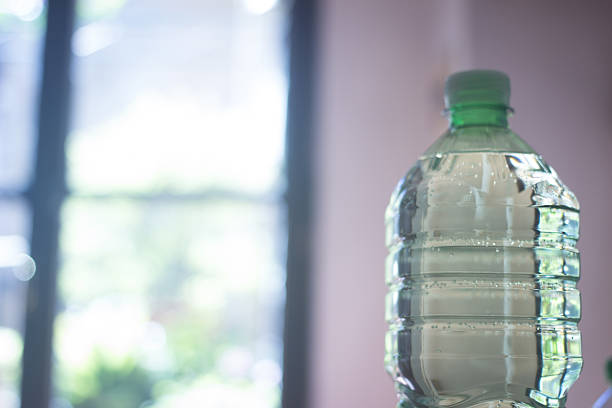 plástico, botella de agua en la ventana de luz - water bottle water bottle drink fotografías e imágenes de stock