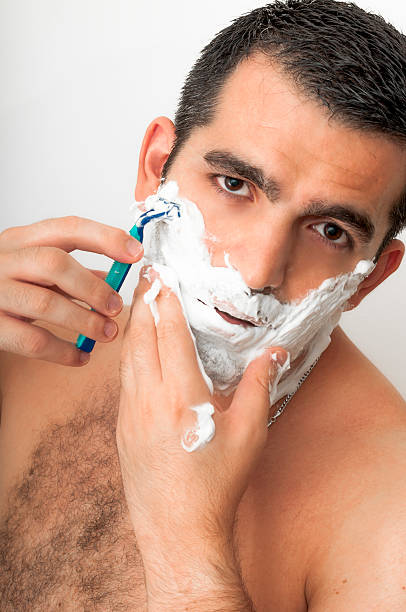 uomo nella sua anni'30 rasatura su sfondo bianco - hairy men shaving chest foto e immagini stock