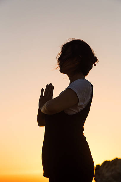 istock Silhouette young woman practicing yoga on the beach at sunset. 480233612