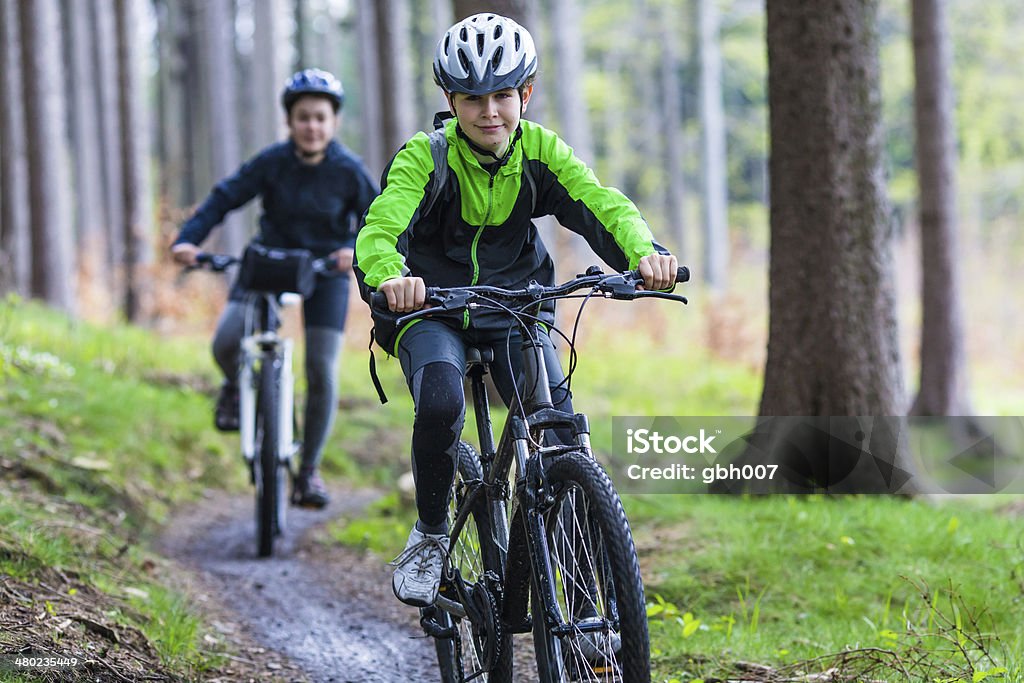 Menina e menino adolescente andar de bicicleta nas trilhas da floresta - Foto de stock de Ciclismo royalty-free