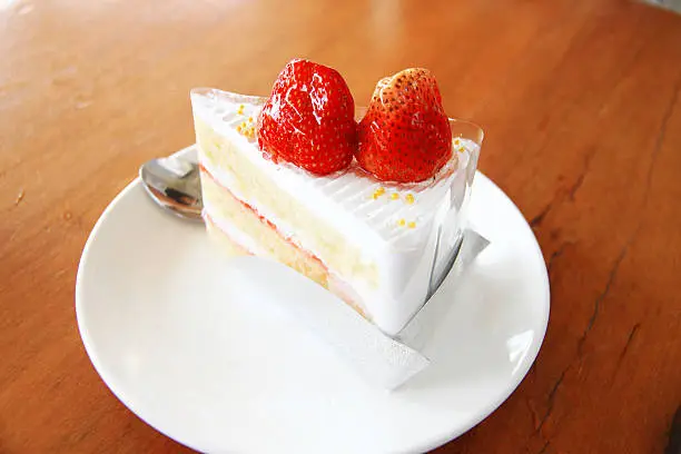 Strawberry cake on wooden table background.