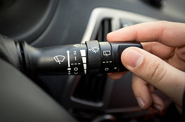 istock male driver adjusting speed of screen wipers in car 480239904