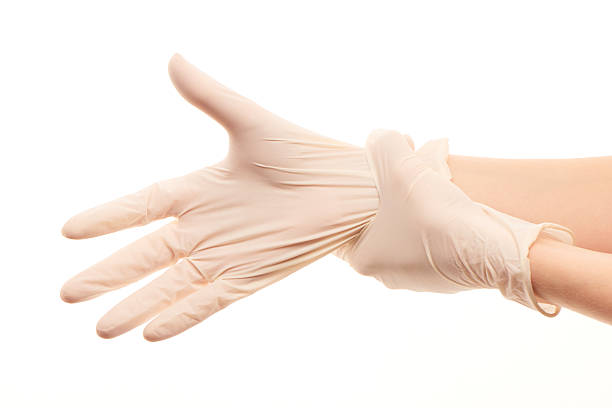 istock Female doctor's hands putting on white sterilized surgical gloves 480243614