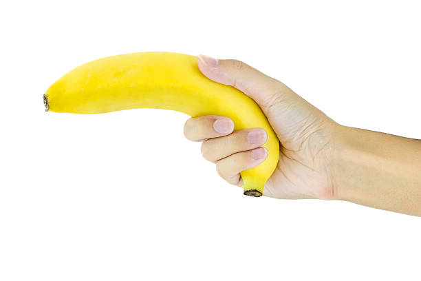 istock Banana in hand like a gun on white background 480255628