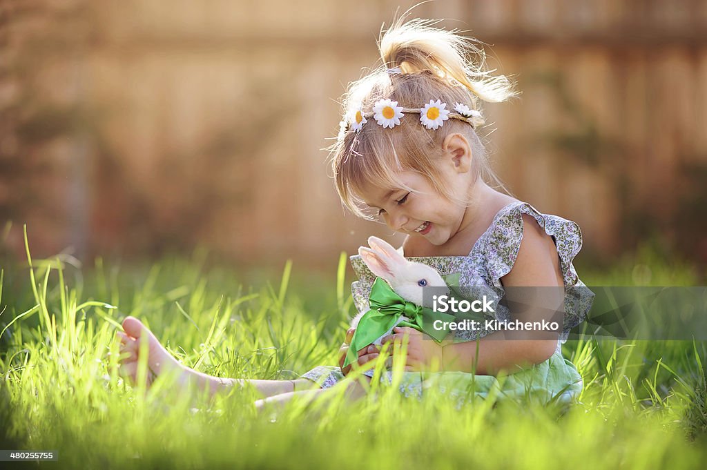 Kleine Mädchen spielen mit einem Hasen auf dem Rasen - Lizenzfrei Ostern Stock-Foto