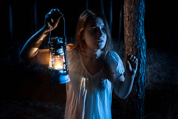 istock scared woman lost in forest lighting up the way with 480258818