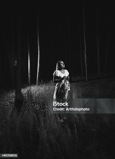 Monochrome Photo Of Woman In Dress Walking At Night Forest Stock Photo - Download Image Now