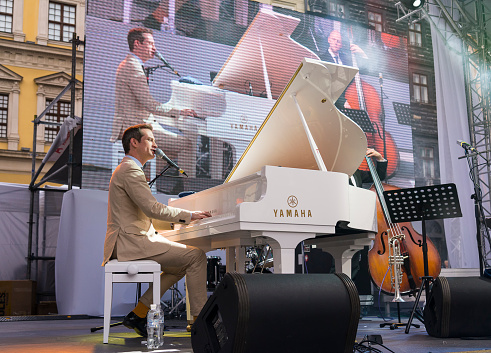  Lviv, Ukraine - 25 June 2015: Alfa Jazz Fest 2015. Antony Strong playing piano on stage jazz festival on the Market Square in Lviv near the town hall.