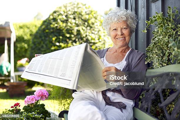 Senior Woman Reading Eine Zeitung Im Garten Des Hotels Stockfoto und mehr Bilder von Gartenanlage