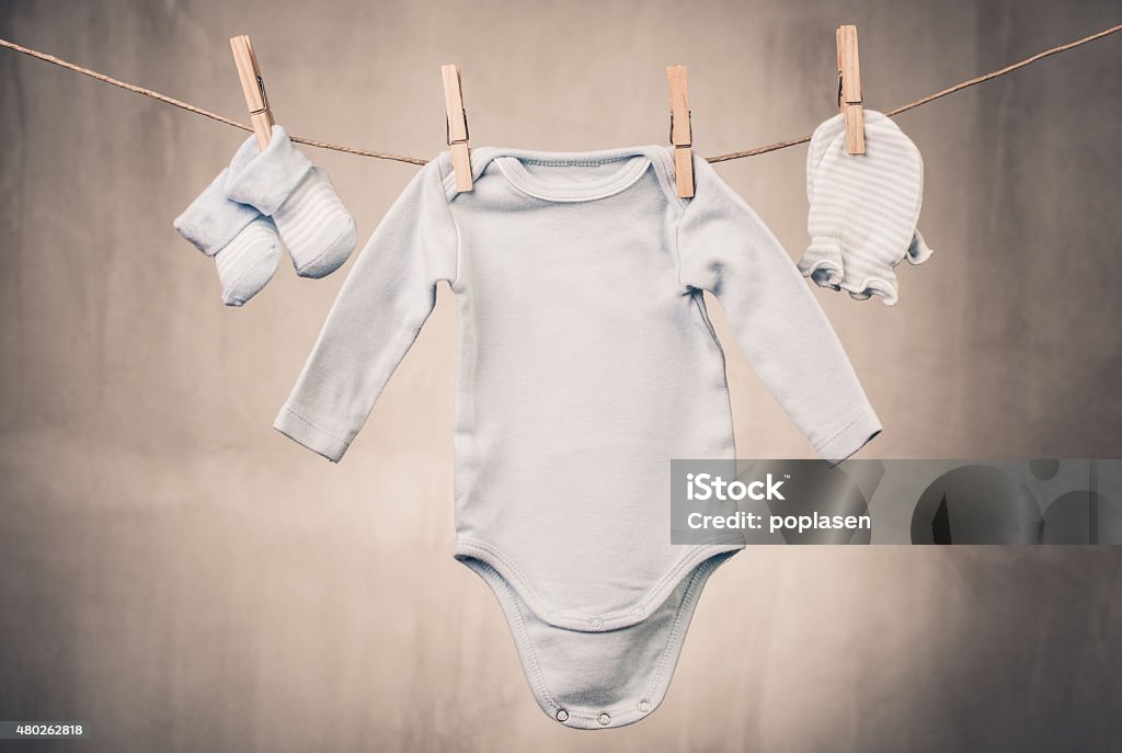 Clothes of a little baby Baby goods hanging on the clothesline Baby - Human Age Stock Photo