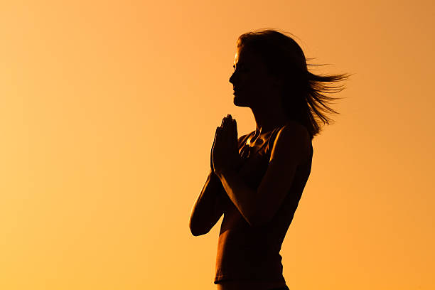 Peace of mind Silhouette of a woman meditating. behavior femininity outdoors horizontal stock pictures, royalty-free photos & images