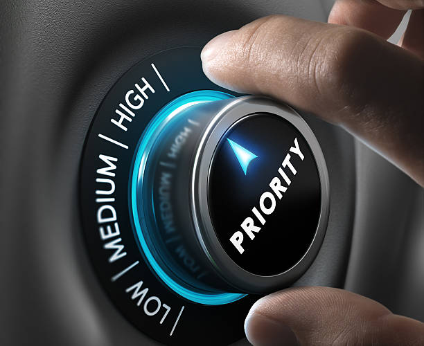 High Priority Man fingers setting priority button on highest position. Concept image for illustration of priorities management. important stock pictures, royalty-free photos & images