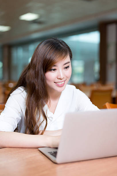 istock Beautiful asian female student using laptop for study in library 480286930