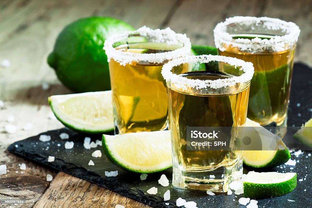 Gold Mexican tequila with lime and salt Gold Mexican tequila with lime and salt, selective focus Tequila - Drink Stock Photo