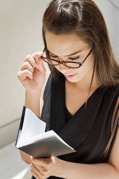 istock business woman looking at her notebook planner 480289729