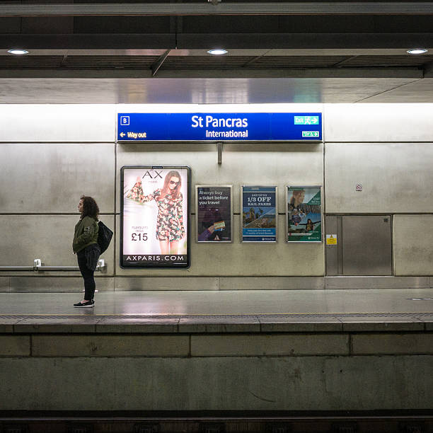 London, UK - 23 April, 2015: A female passenger waiting on an underground platform at St. Pancras International train station.