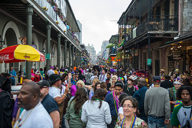 Crowd on Bourbon Street - Mardi Gras 2013 Bourbon Street swells with people celebrating Fat Tuesday, the final day of Mardi Gras, in the French Quarter of New Orleans. new orleans mardi gras stock pictures, royalty-free photos & images