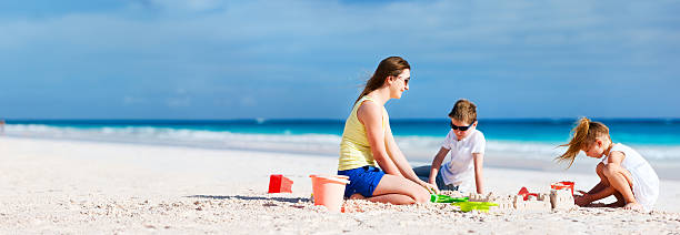 istock Mother and kids playing at beach 480295851