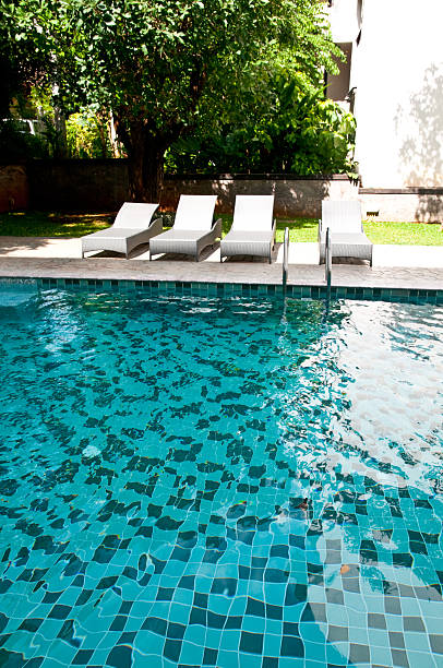 istock swimming pool with white fashion deckchairs 480296042