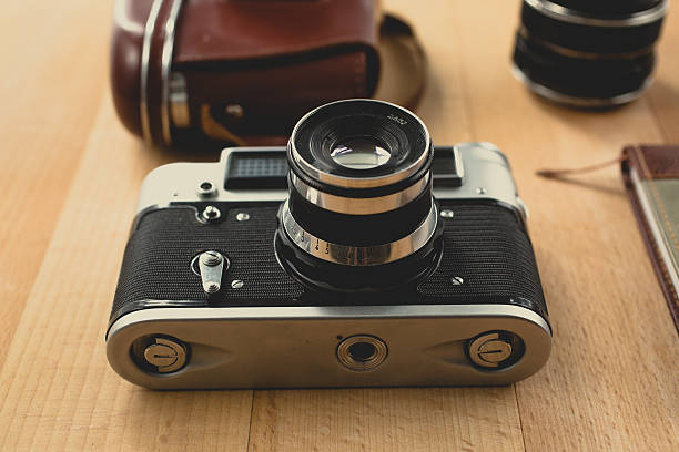 istock Toned retro shot of camera with portrait lens on table 480305708