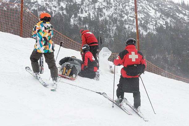 Ski Patrol Rescues Injured Skier Whiteface Ski Area, Wilmington, NY, USA - March 15th, 2014: The Whiteface Mountain Ski Patrol rescues a fallen skier by loading the injured skier into a ski patrol rescue sled. ski patrol photos stock pictures, royalty-free photos & images