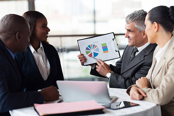 istock senior businessman showing a graph to business team 480308781