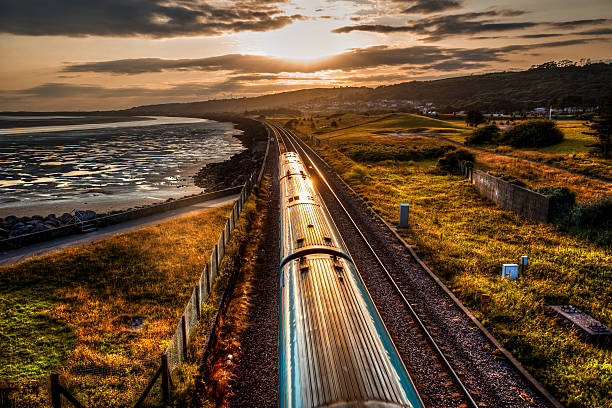 istock Train travelling past sea wall at sunset 480310612