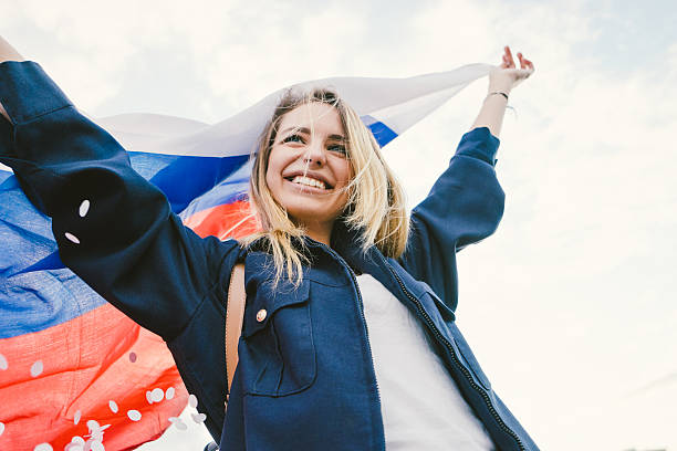 Cheering Woman Under Russian Flag Cheering woman under Russian flag. russian ethnicity stock pictures, royalty-free photos & images