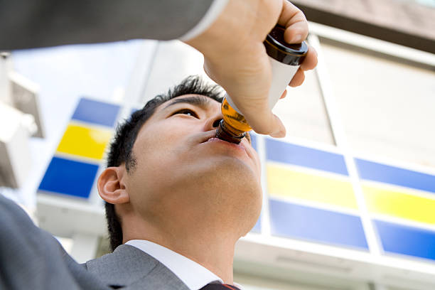 Man drinking energy drink in front of convenience store Man drinking energy drink in front of convenience store energy drink photos stock pictures, royalty-free photos & images