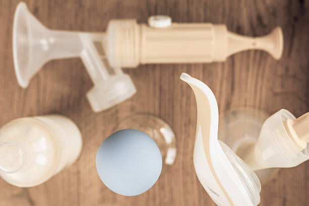 istock Background of manual, automatic breast pump, baby bottle with milk 480311556