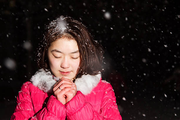 young female praying in snow
