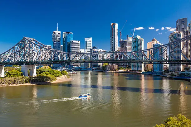 Ferry boat under Story Bridge with skyline of Brisbane, Queensland, Australia