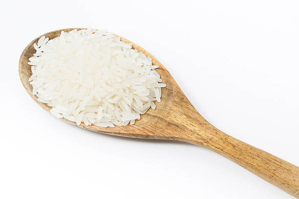 istock rice and a wooden spoon on a white background. 480315084