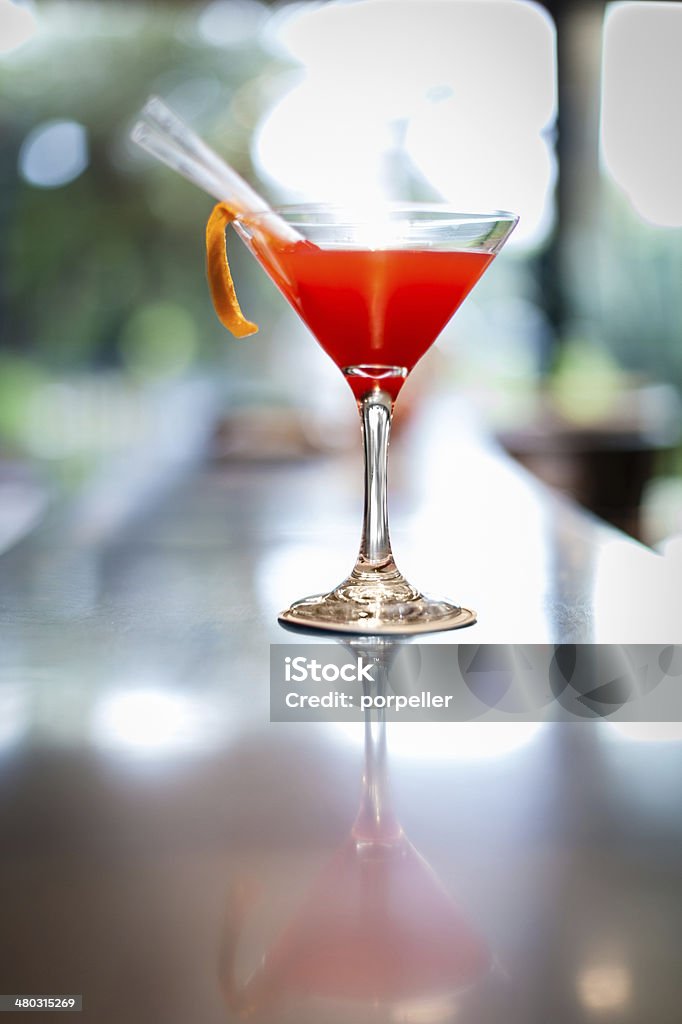 Bar counter a refreshing cocktail with a decorative orange peel and a straw Alcohol - Drink Stock Photo