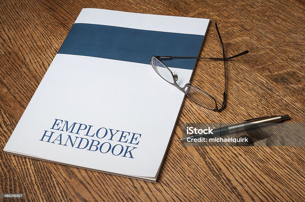 Employee handbook Employee handbook manual on a desktop with glasses and a mechanical pencil Handbook Stock Photo