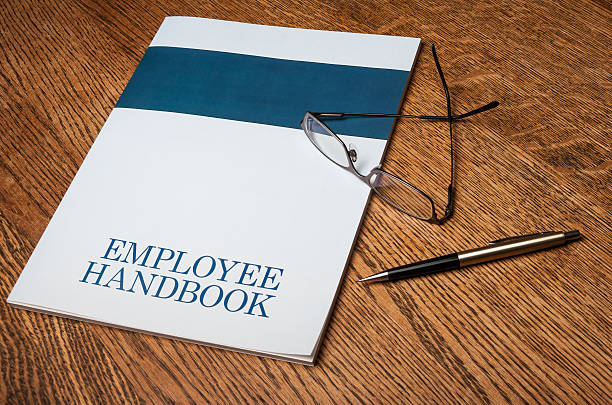 Employee handbook Employee handbook manual on a desktop with glasses and a mechanical pencil handbook photos stock pictures, royalty-free photos & images