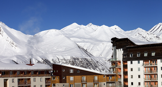 Snowy hotels in winter mountains at nice day. Caucasus Mountains, Georgia, ski resort Gudauri. Panoramic view.