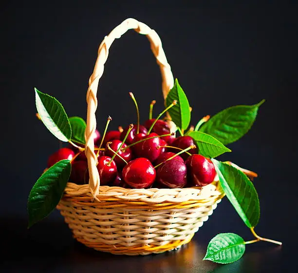 Photo of Food. cherry in wicker basket black isolated