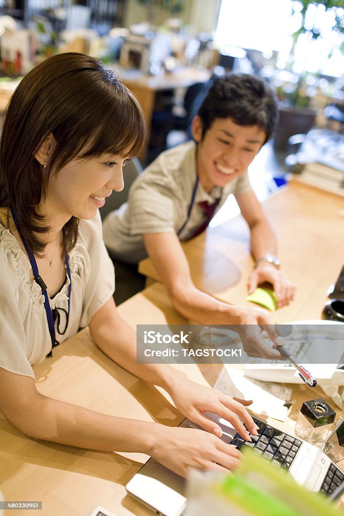 Man and woman at desk with PC Asian and Indian Ethnicities Stock Photo