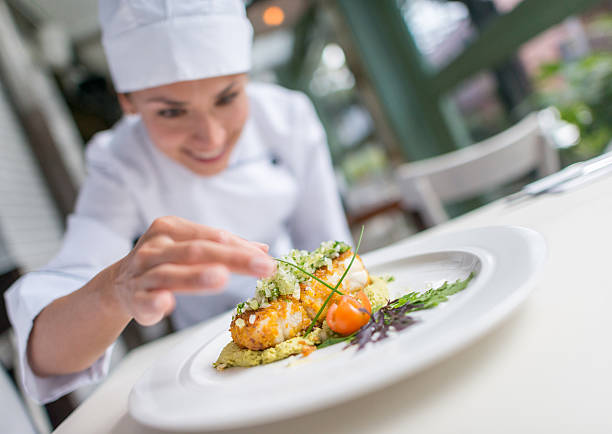 cozinhe decorando um belo prato - serving food restaurant chicken - fotografias e filmes do acervo