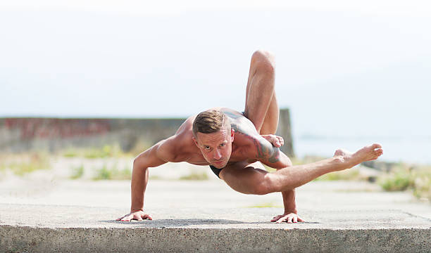 istock man practices yoga and gymnastics 480336838