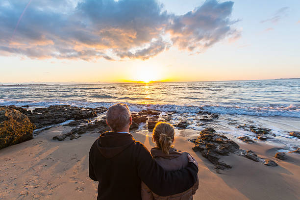 istock Couple in love watching a sunset on the beach 480344576